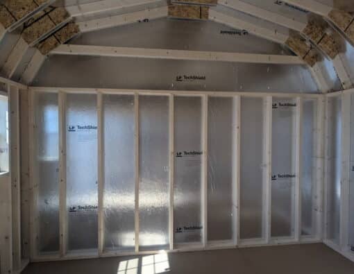 12x16 size vinyl high barn roof style shed with flint siding, white trim, estate gray architectural shingle roof, black shutters. has 8' ridge vent, 6 foot fiber double doors and two windows.