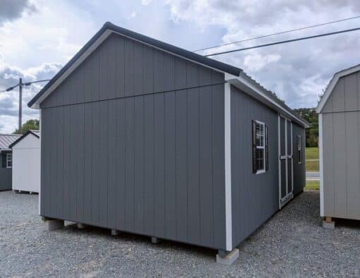 14 x 28 size painted classic garage style shed with gray siding, white trim, black metal roof, black shutters, garage door with glass, ggs 6 foot double doors 1' ft taller, two windows.