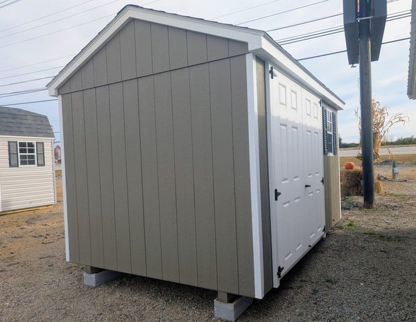 8 x 12 size painted a-roof style shed with clay siding, white trim, driftwood architectural shingle roof, black shutters, (1) 8' ridge vent, fiber solid 6 foot double doors, one window.