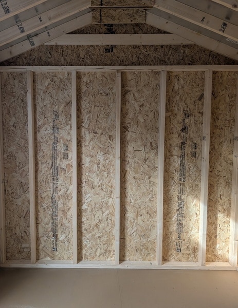 8 x 12 size painted a-roof style shed with clay siding, white trim, driftwood architectural shingle roof, black shutters, (1) 8' ridge vent, fiber solid 6 foot double doors, one window.