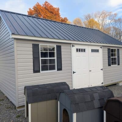 12 x 20 size vinyl garden style shed with flint siding, white trim, black metal roof, black shutters, fiber transom 6 foot double shed doors, two windows.