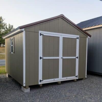 10 x 12 size painted a-roof style shed with clay siding, white trim, brown metal roof, brown shutters, ggs 6 foot doors, two windows.