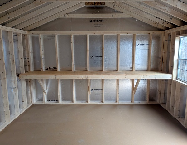 12x20 size vinyl a-roof style shed with white siding, white trim, black metal roof, black shutters. Has 6 foot fiber double doors and two windows.