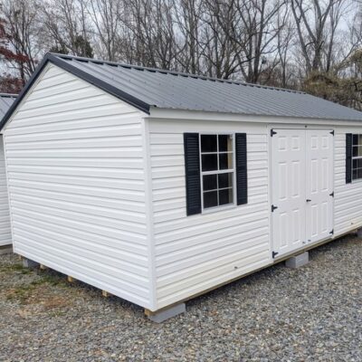 12x20 size vinyl a-roof style shed with white siding, white trim, black metal roof, black shutters. Has 6 foot fiber double doors and two windows.
