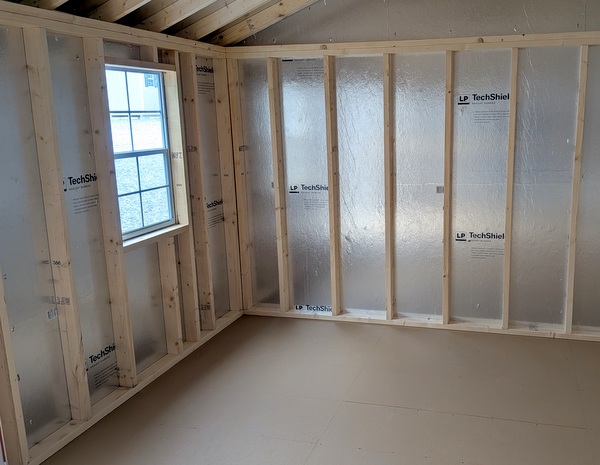 12x20 size vinyl a-roof style shed with white siding, white trim, black metal roof, black shutters. Has 6 foot fiber double doors and two windows.