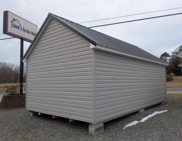 12 x 20 size vinyl garden style shed with flint siding, white trim, black metal roof, black shutters, fiber transom 6 foot double shed doors, two windows.
