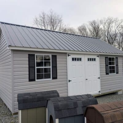 12 x 20 size vinyl garden style shed with flint siding, white trim, black metal roof, black shutters, fiber transom 6 foot double shed doors, two windows.