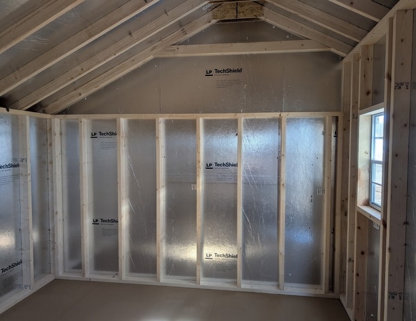 10x12 size vinyl carriage style shed with white siding, white trim, black architectural shingle roof, black shutters. has (1) 8' ridge vent, 6 foot fiber doors and two windows.