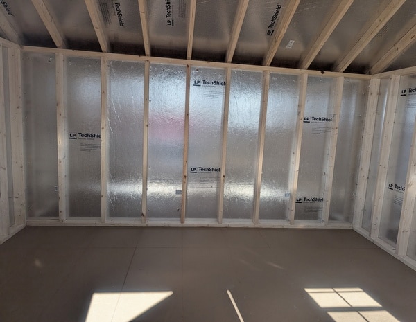 10x12 size vinyl carriage style shed with white siding, white trim, black architectural shingle roof, black shutters. has (1) 8' ridge vent, 6 foot fiber doors and two windows.