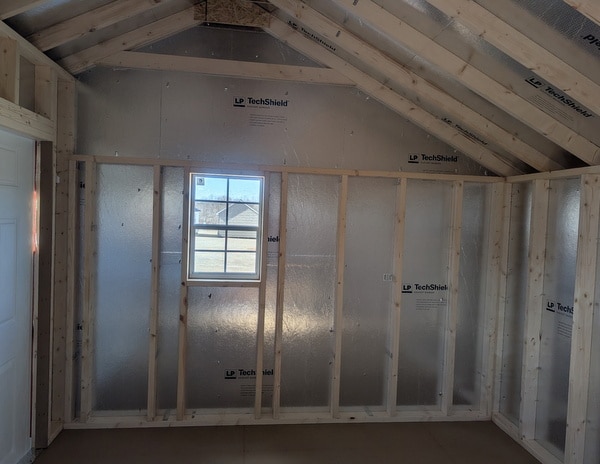 10x12 size vinyl carriage style shed with white siding, white trim, black architectural shingle roof, black shutters. has (1) 8' ridge vent, 6 foot fiber doors and two windows.