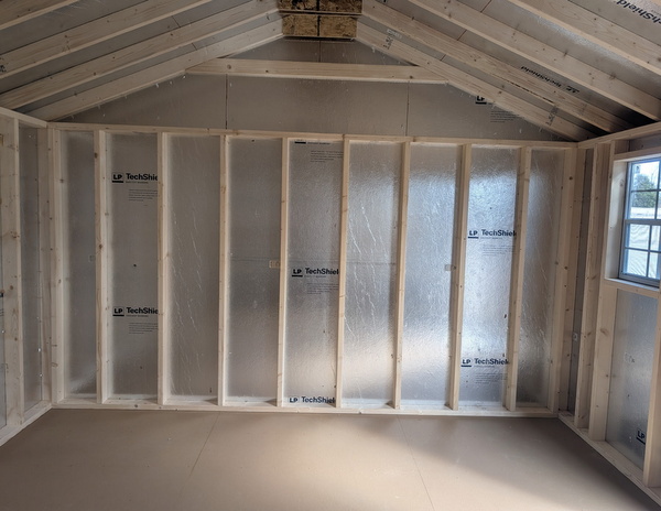 12x16 size vinyl a-roof style shed with flint siding, white trim, black metal roof, black shutters. Has 6 foot fiber double doors and two windows.