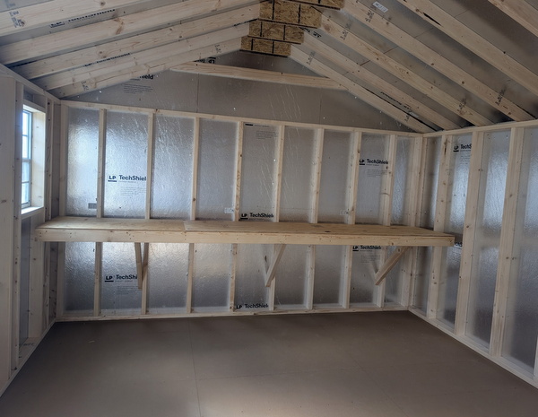 12x16 size vinyl a-roof style shed with flint siding, white trim, black metal roof, black shutters. Has 6 foot fiber double doors and two windows.