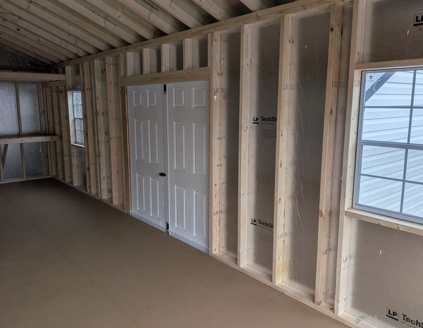 14 x 28 size vinyl a-roof garage style shed with flint siding, white trim, black metal roof, black shutters, 9x7 garage door, 6 foot fiber double doors with two windows.