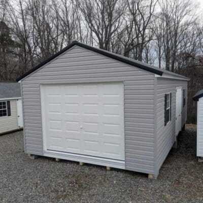 14 x 28 size vinyl a-roof garage style shed with flint siding, white trim, black metal roof, black shutters, 9x7 garage door, 6 foot fiber double doors with two windows.