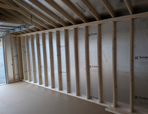 14 x 28 size vinyl a-roof garage style shed with flint siding, white trim, black metal roof, black shutters, 9x7 garage door, 6 foot fiber double doors with two windows.