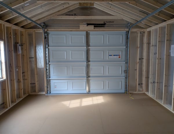14 x 28 size vinyl a-roof garage style shed with flint siding, white trim, black metal roof, black shutters, 9x7 garage door, 6 foot fiber double doors with two windows.