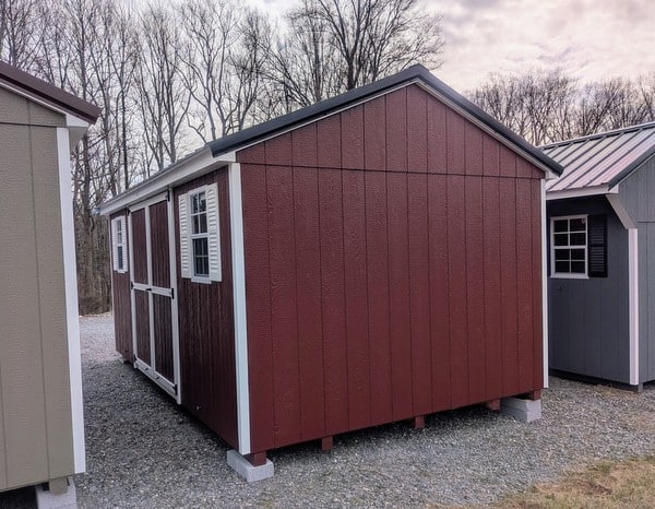 10 x 16 size painted a-roof style shed with pinnacle red siding, white trim, black metal roof, white shutters, ggs 6 foot double doors, two windows.