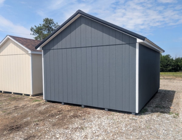 12 x 16 size painted classic style shed with gray siding, white trim, black metal roof, black shutters, ggs 6 foot double doors, two windows.