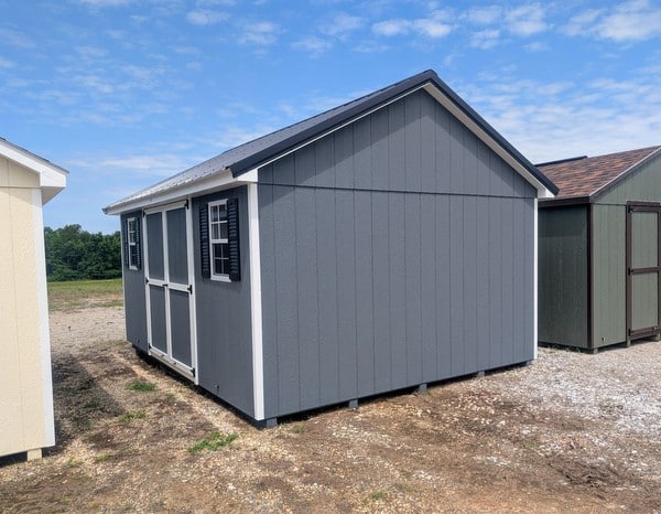 12 x 16 size painted classic style shed with gray siding, white trim, black metal roof, black shutters, ggs 6 foot double doors, two windows.