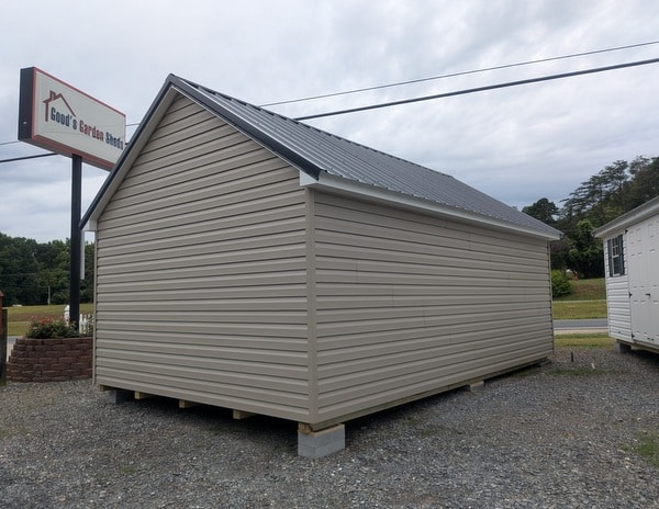 12 x 20 size vinyl garden style shed with clay siding, white trim, black metal roof, black shutters, fiber 9 lite 6 foot double shed doors, two windows.