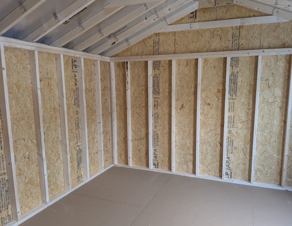 12x20 size vinyl a-roof style shed with clay siding, white trim, black metal roof, black shutters. Has 6 foot 2 plank double doors and two windows.