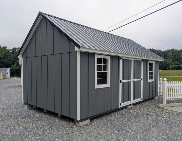 12 x 20 size painted garden board & batten style shed with gray board & batten siding, white trim, black metal roof, ggs 6 foot double doors, two windows.