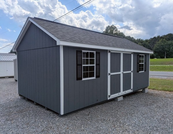 12 x 20 size painted classic style shed with gray siding, white trim, black architectural shingle roof, black shutters, (2) 10' ridge vents, ggs 6 foot double doors, two windows.