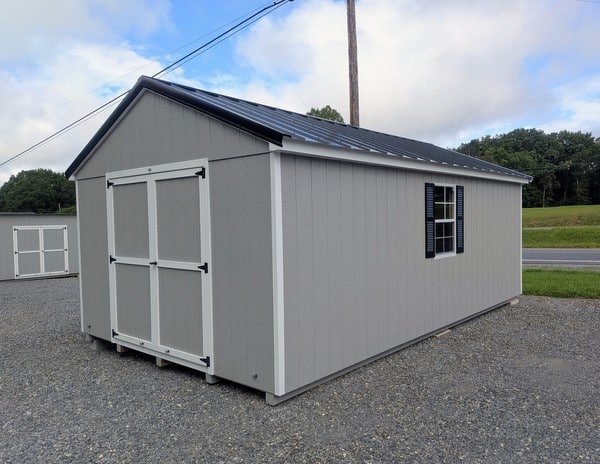 12 x 20 size painted a-roof style shed with gap gray siding, white trim, black metal roof, black shutters, legacy metal roof style, ggs 6 foot double doors, two windows.