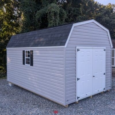 10x16 size vinyl high barn roof style shed with flint siding, white trim, black architectural shingle roof, black shutters. has 10' ridge vent, 6 foot fiber double doors and two windows.