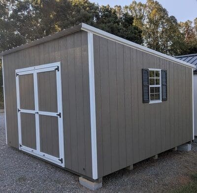 12x12 size painted economy style shed with clay siding, white trim, alamo metal roof, black shutters, ggs 6 foot doors with two windows.