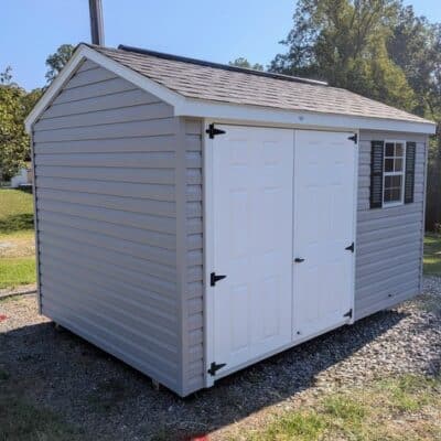8x12 size vinyl a-roof style shed with flint siding, white trim, black architectural shingle roof, black shutters. Has 10' ridge vent, 6 foot fiber double doors and one window.