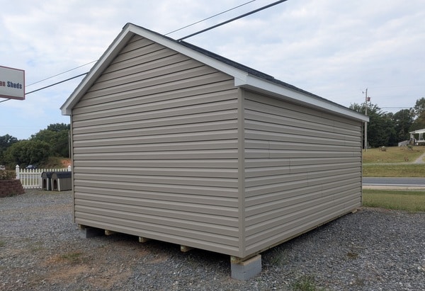 12x16 size vinyl classic style shed with clay siding, white trim, black architectural shingle roof, black shutters. has (1) 10' ridge vent, fiber solid 6 foot double doors and two windows