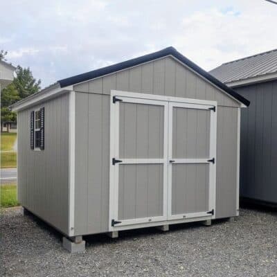 10 x 12 size painted a-roof style shed with gap gray siding, white trim, black metal roof, black shutters, ggs 6 foot doors, two windows.