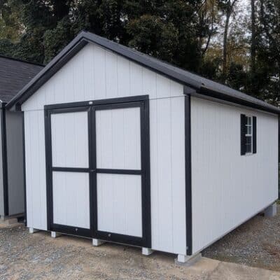10 x 16 size painted classic style shed with white siding, black trim, black metal roof, black shutters, ggs 6 foot double doors, two windows.